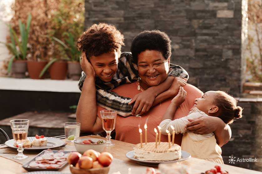 woman hugging her children at a table with food