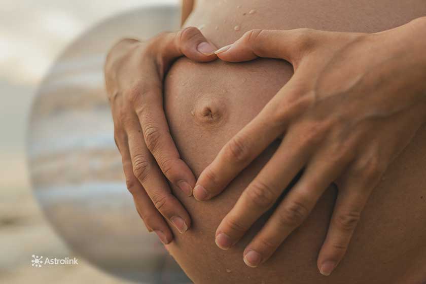 pregnant woman's belly with hands in heart shape